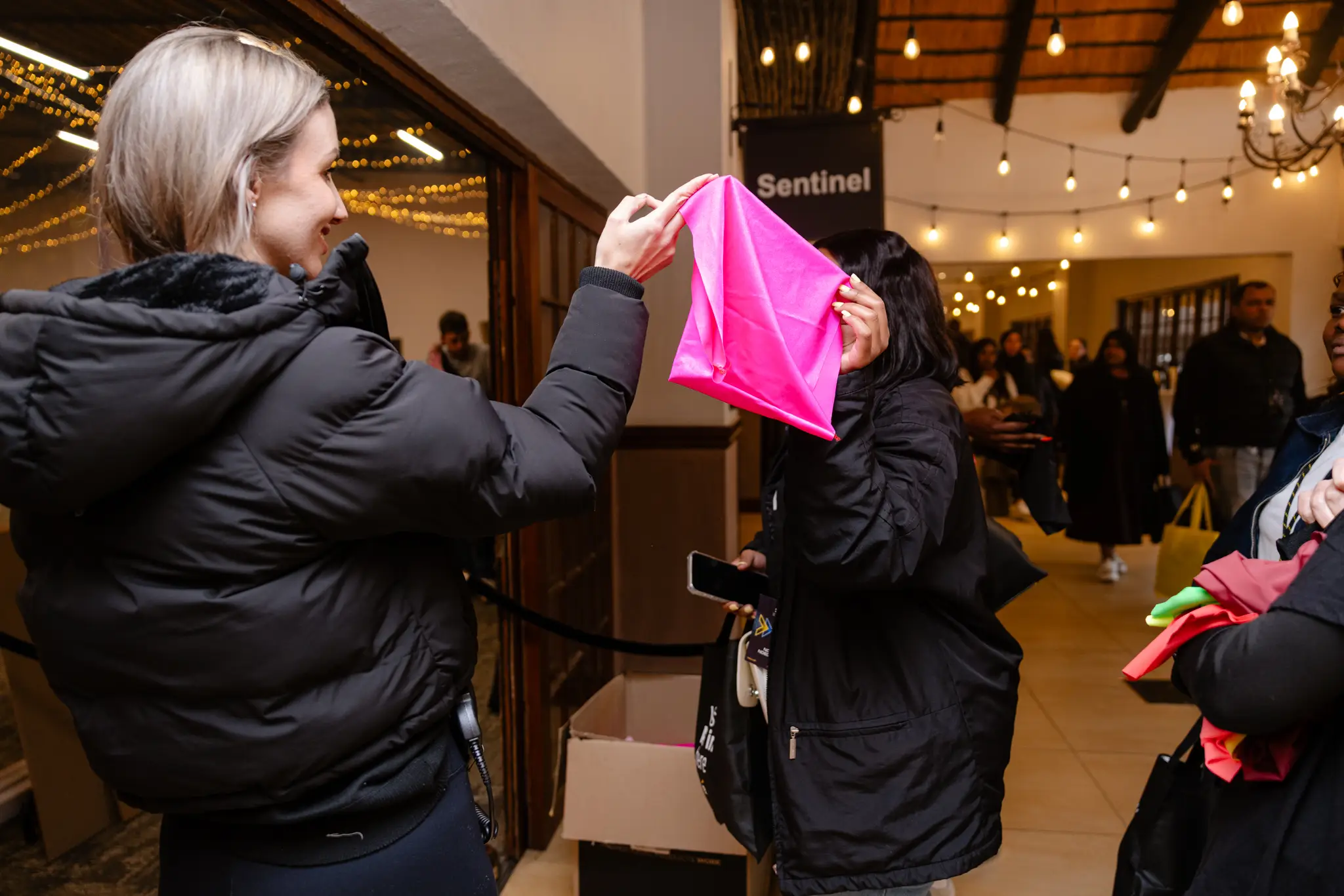 A SYNC'D team member hands out branded gear to guests at an event